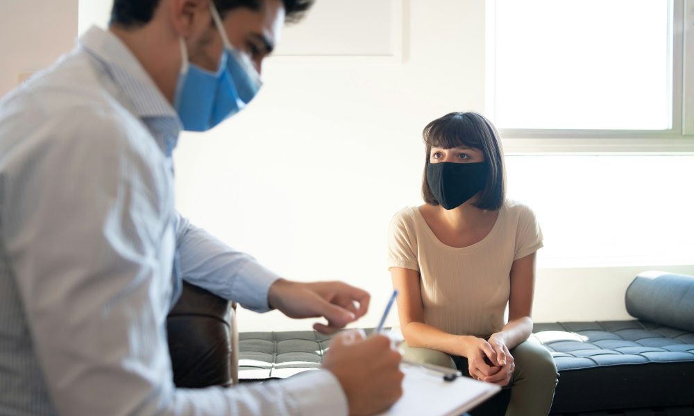 Psychologist taking notes during therapy session.